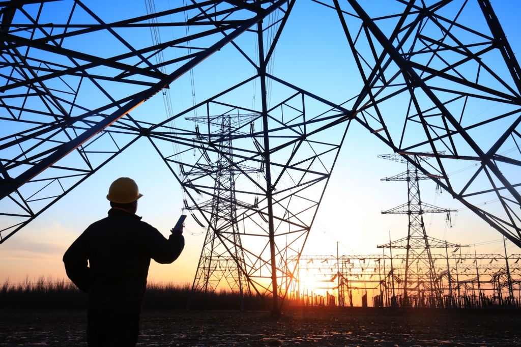 Electricity workers and pylon silhouette