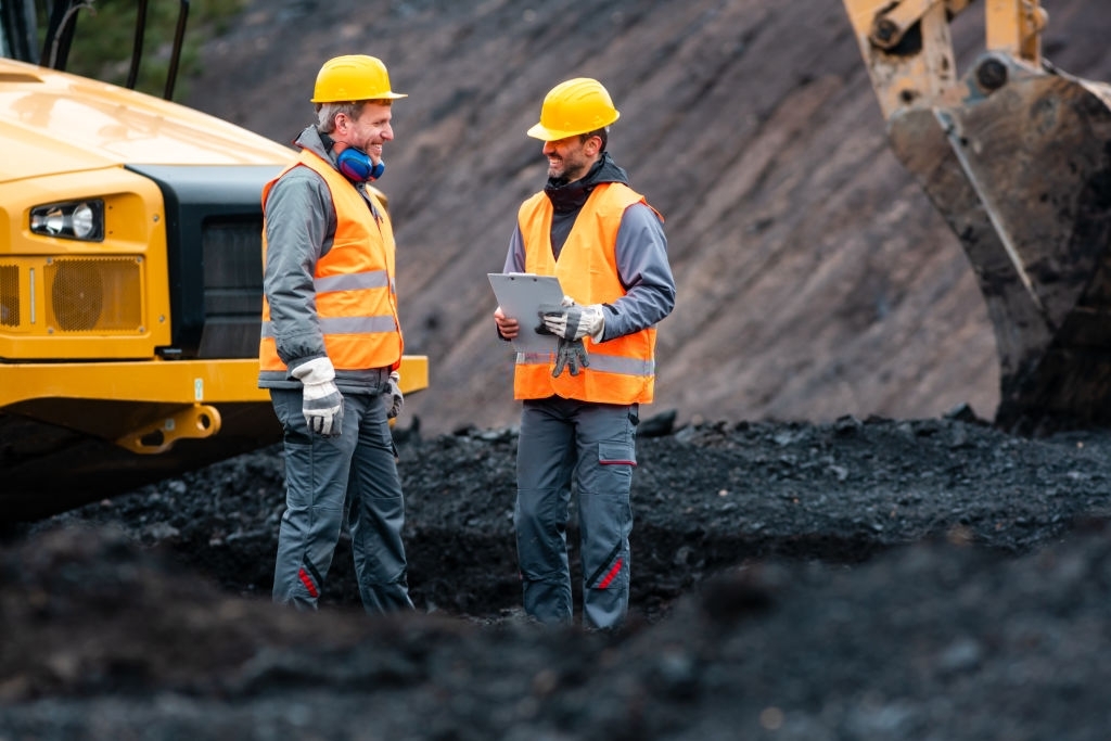Worker with a plan and a clipboard discussing super important things in quarry